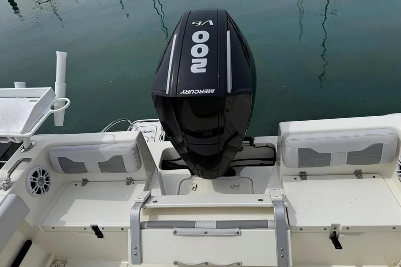 Slide: The Image of 2024 Mako 214 Center Console boat with Mercury 200 engine, docked on calm water. - 9