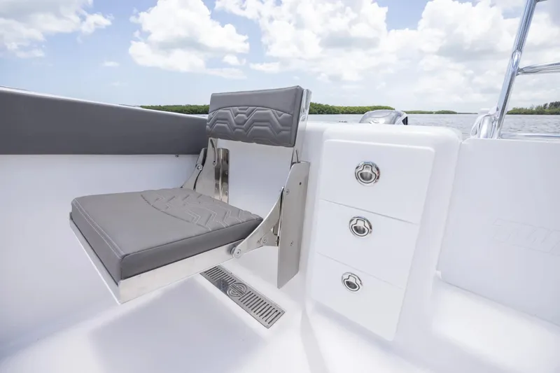 Slide: The Image of 2026 Twin Vee 340 GFX CC boat seat and storage drawers under a clear sky. - 13