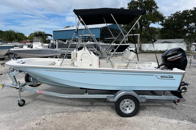 Slide: The Image of 2026 Boston Whaler 150 Montauk boat on trailer, side view. - 5