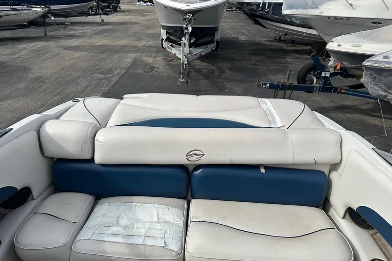 Slide: The Image of 2007 Crownline 19 SS boat interior with white and blue seating, parked among other boats. - 11