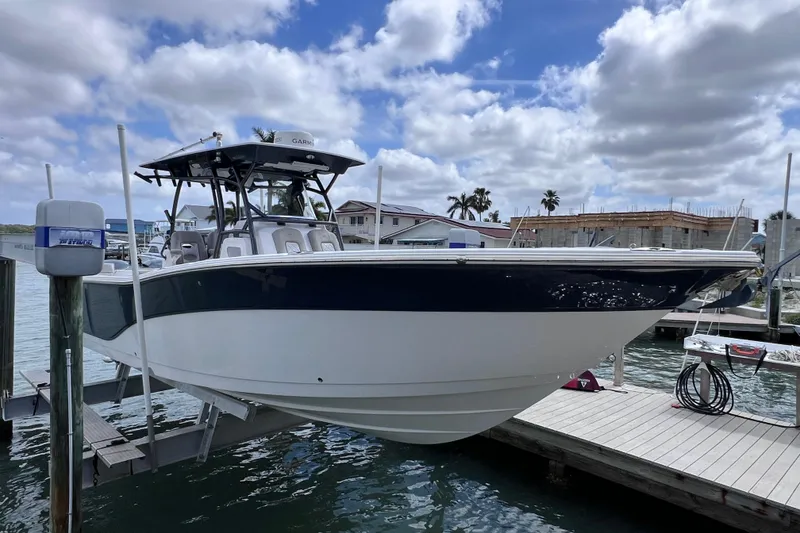 Slide: The Image of 2019 Sea Fox 328 Commander boat docked at marina under cloudy sky. - 12