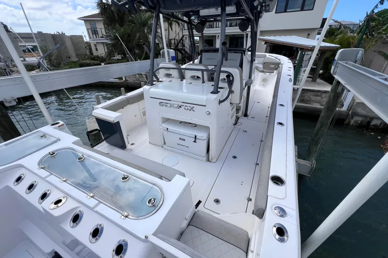 Slide: The Image of 2019 Sea Fox 328 Commander boat docked, showcasing spacious deck and seating area. - 17