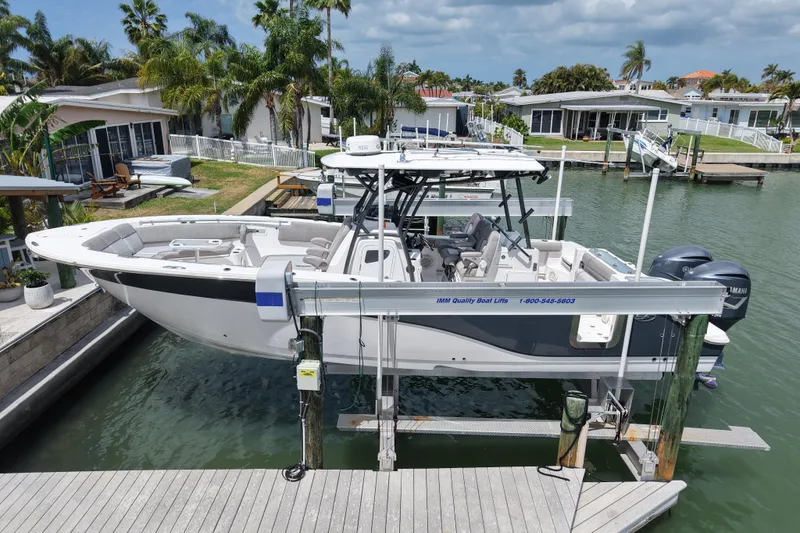 Slide: The Image of 2019 Sea Fox 328 Commander boat on lift, docked in a scenic waterfront area. - 2