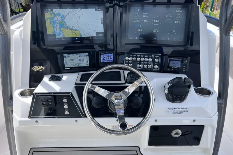 Slide: The Image of Control panel of a 2019 Sea Fox 328 Commander boat with navigation screens and steering wheel. - 32