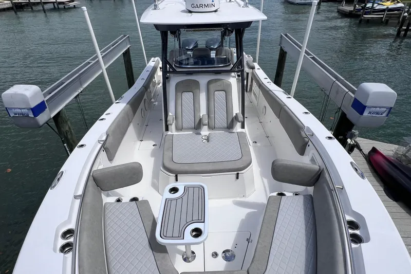 Slide: The Image of 2019 Sea Fox 328 Commander boat interior with seating and table, docked by the water. - 48