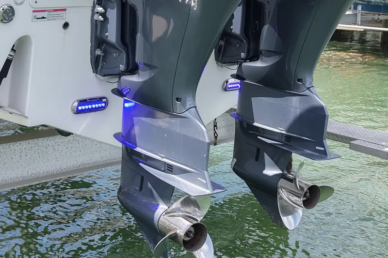Slide: The Image of Twin outboard motors on a 2019 Sea Fox 328 Commander boat, illuminated by blue lights. - 7