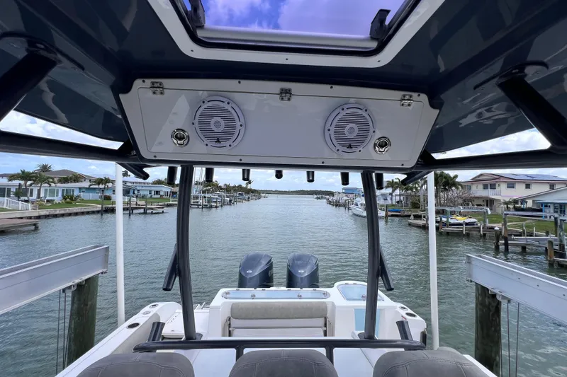 Slide: The Image of 2019 Sea Fox 328 Commander boat interior with dual engines, docked in a scenic waterfront area. - 75