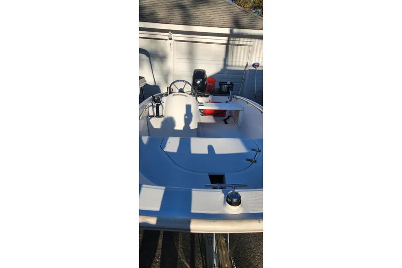 Slide: The Image of 2011 Boston Whaler 130 Super Sport boat in driveway, showcasing interior and controls. - 2