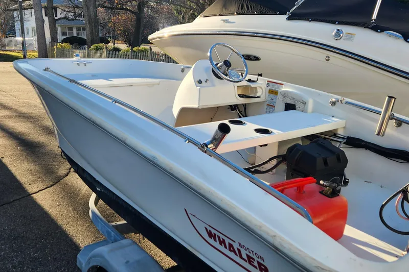Slide: The Image of 2011 Boston Whaler 130 Super Sport boat on trailer, parked outdoors. - 5