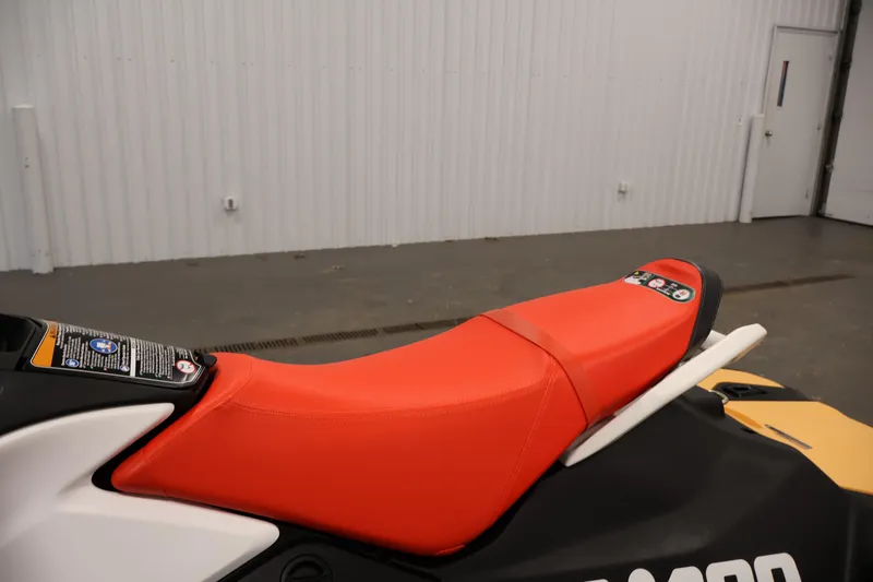 Slide: The Image of 2025 Sea-Doo Spark 2up with vibrant red seat in a showroom setting. - 14