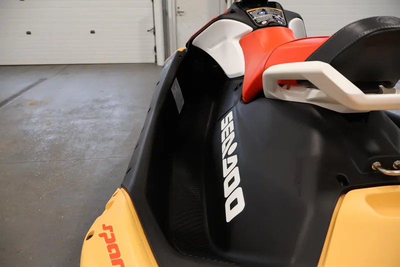 Slide: The Image of 2025 Sea-Doo Spark 2up jet ski with vibrant red and black seat in a garage setting. - 15