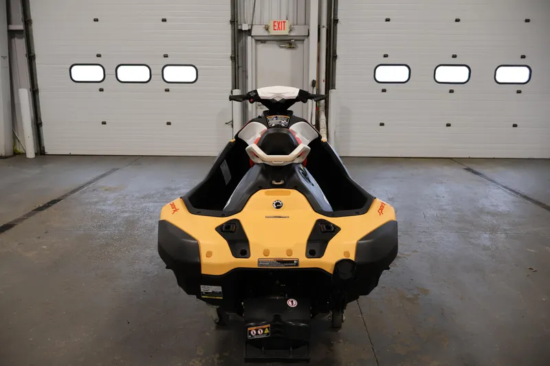 Slide: The Image of 2025 Sea-Doo Spark 2up jet ski in a garage, rear view. - 6