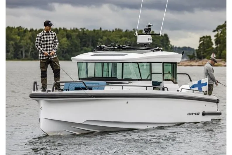 Slide: The Image of 2027 Axopar 37 XC Cross Cabin boat on water with two people fishing. - 2