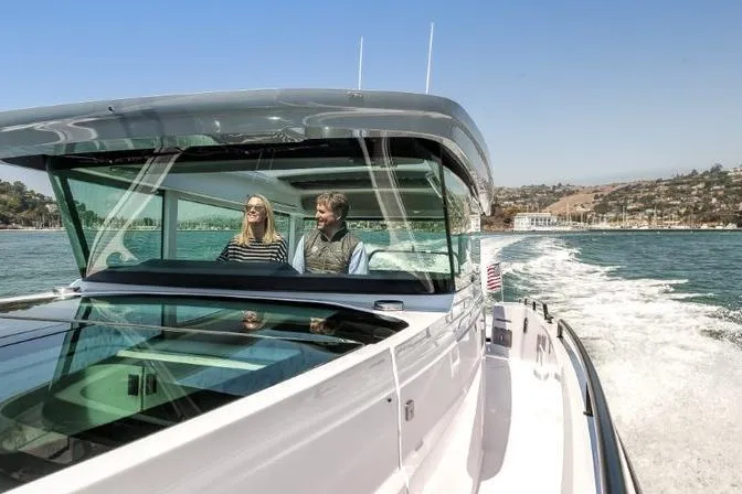 Slide: The Image of 2027 Axopar 37 XC Cross Cabin cruising on open water with two passengers onboard. - 3