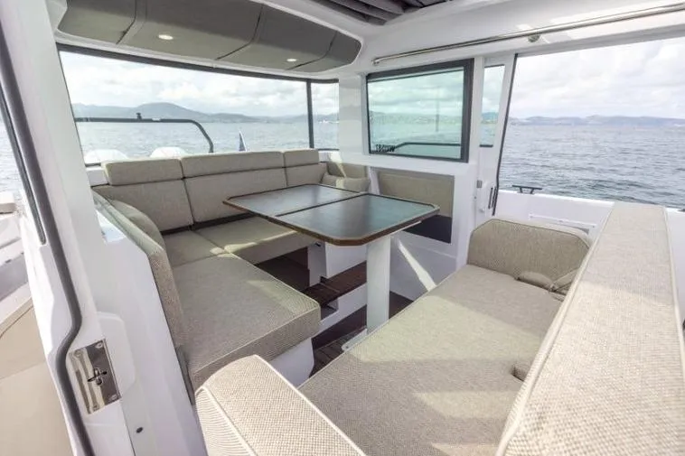 Slide: The Image of 2027 Axopar 37 XC Cross Cabin interior with spacious seating and ocean view. - 6