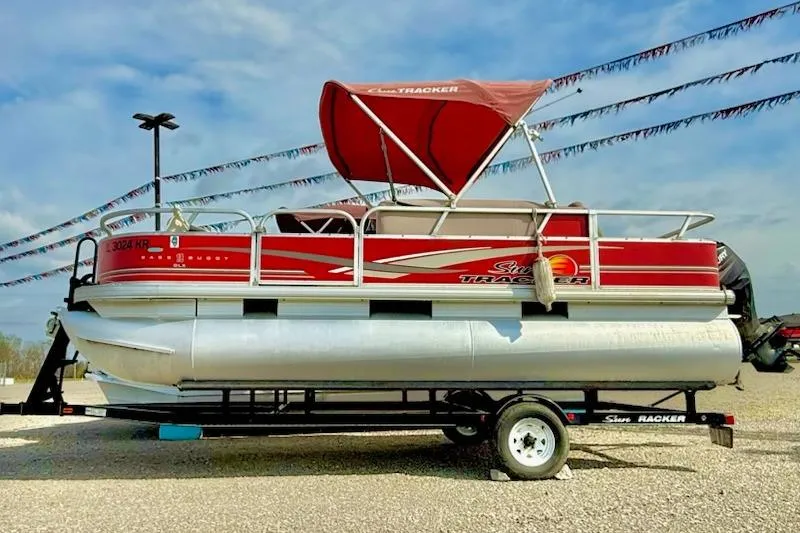 The Image of 2014 Sun Tracker Bass Buggy 18 DLX pontoon boat with red canopy on trailer. - 1