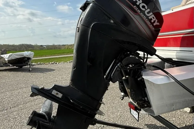 Slide: The Image of 2014 Sun Tracker Bass Buggy 18 DLX with Mercury outboard motor on gravel surface. - 5