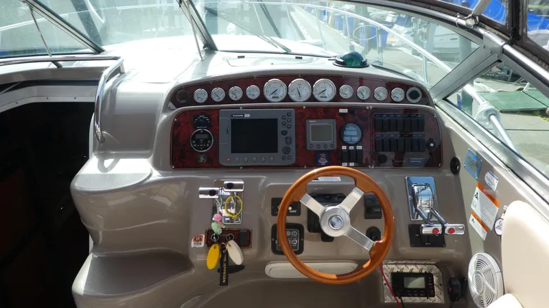 Slide: The Image of Cockpit of a 2004 Larson 370 boat with steering wheel and control panel. - 12