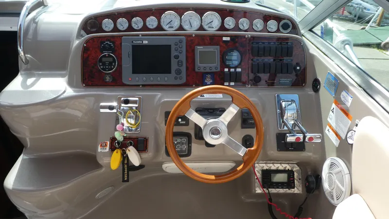 Slide: The Image of Control panel of a 2004 Larson 370 boat with gauges and steering wheel. - 13