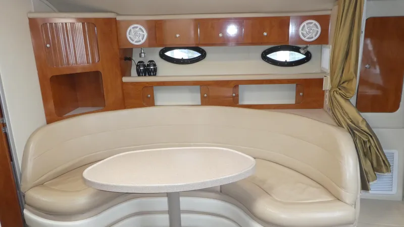 Slide: The Image of 2004 Larson 370 yacht interior with beige seating and wooden cabinetry. - 17