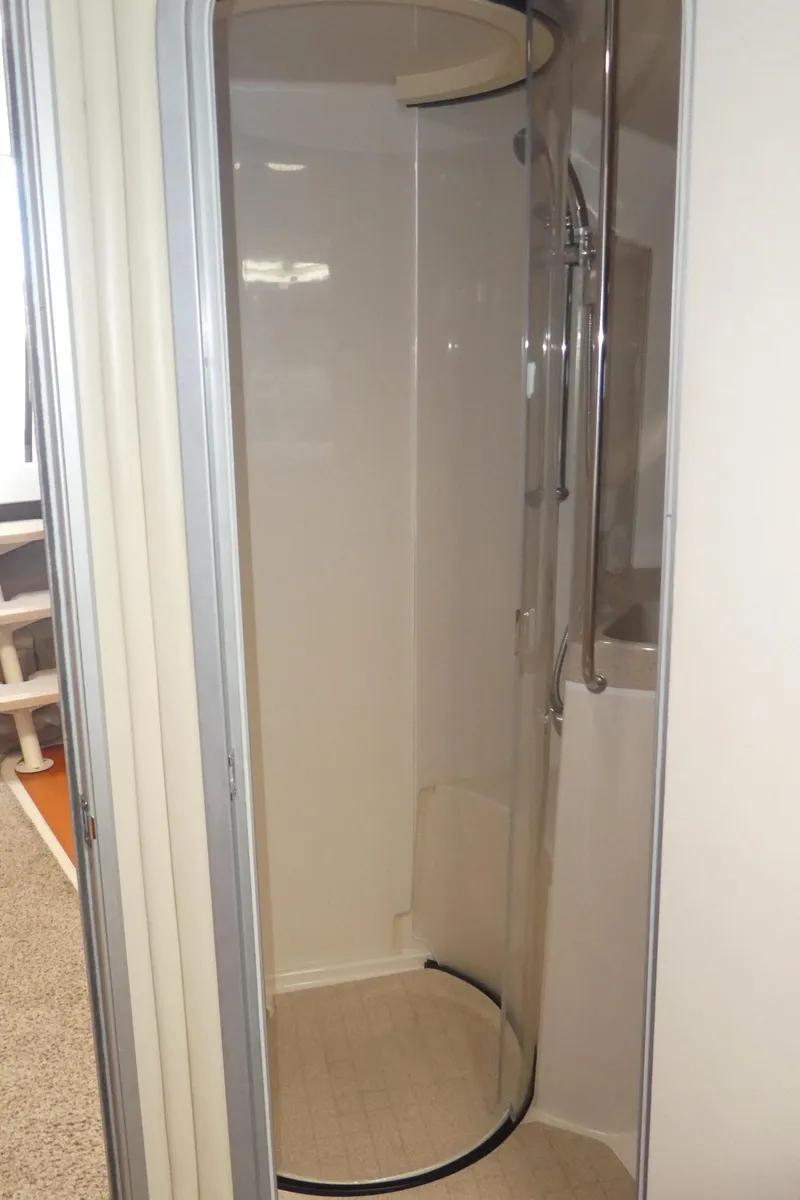 Slide: The Image of Shower area in a 2004 Larson 370 boat, featuring a curved glass door. - 27