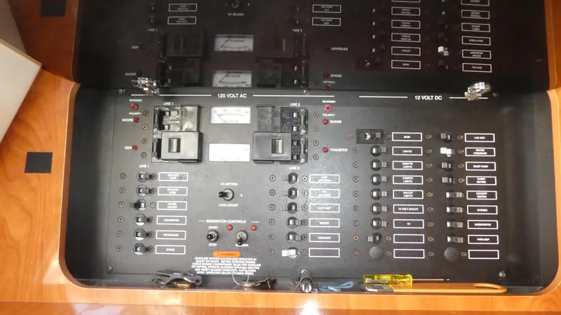 Slide: The Image of Electrical panel of a 2004 Larson 370 boat, featuring AC and DC circuit breakers. - 28