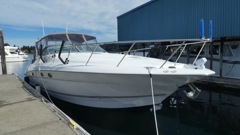 Slide: The Image of 2004 Larson 370 boat docked at marina, featuring sleek white design and spacious deck. - 32