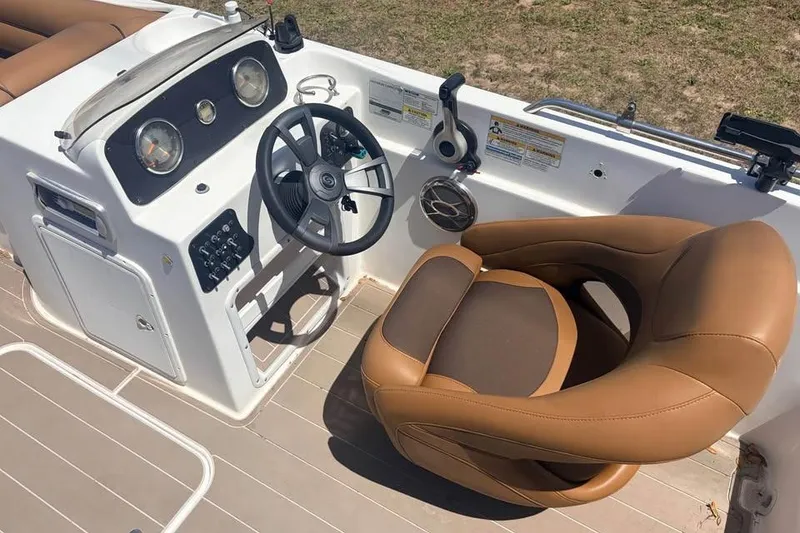 Slide: The Image of 2014 Hurricane SunDeck Sport 201 OB boat cockpit with steering wheel and brown captain's chair. - 10