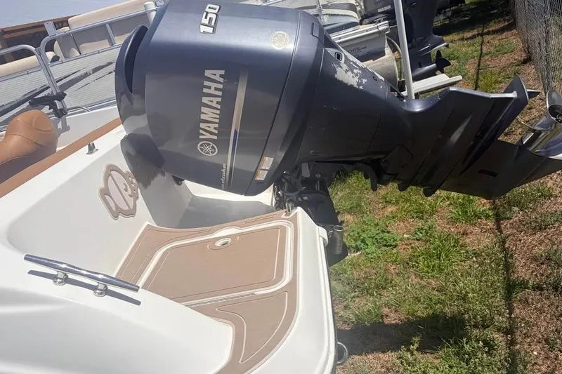 Slide: The Image of 2014 Hurricane SunDeck Sport 201 OB with Yamaha 150 outboard motor, docked on grass. - 7