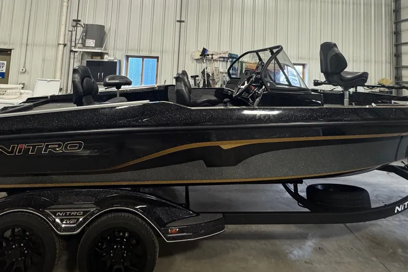 Slide: The Image of 2026 Nitro ZV21 boat in a garage, featuring sleek black design and comfortable seating. - 2