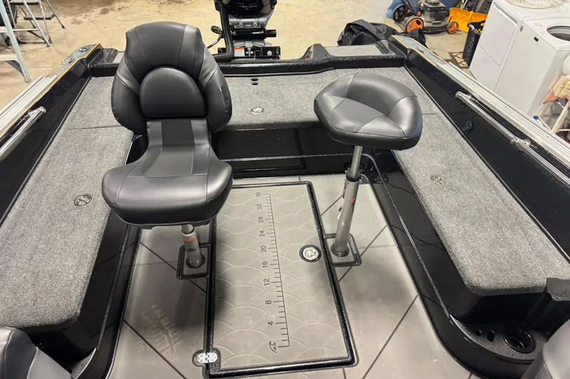 Slide: The Image of Interior of a 2026 Nitro ZV21 boat with two black seats and carpeted flooring. - 9