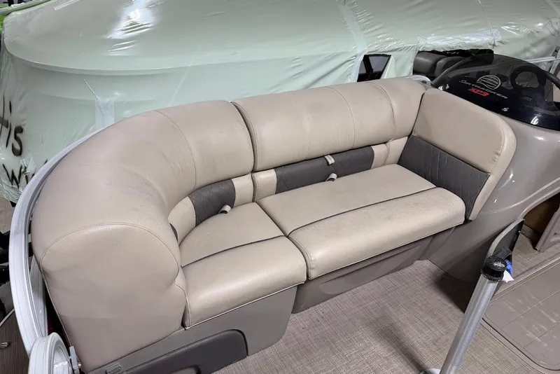 Slide: The Image of 2022 SUNTRACKER 22 DLX boat interior with beige cushioned seating. - 12