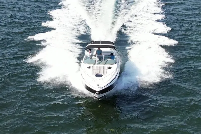 Slide: The Image of 2016 Regal 32 Express cruising on open water, creating a dynamic wake. - 11
