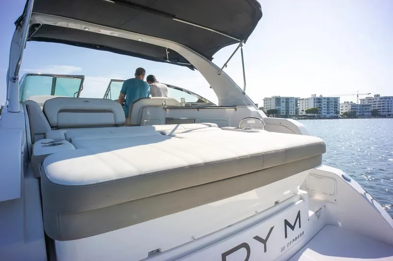 Slide: The Image of 2016 Regal 32 Express yacht with sunbed, docked near waterfront buildings. - 13