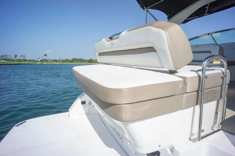 Slide: The Image of 2016 Regal 32 Express boat with cushioned seating, docked on calm water. - 15