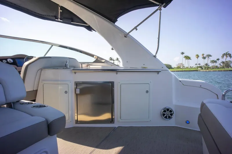 Slide: The Image of 2016 Regal 32 Express boat interior with seating, cabinetry, and water view. - 20