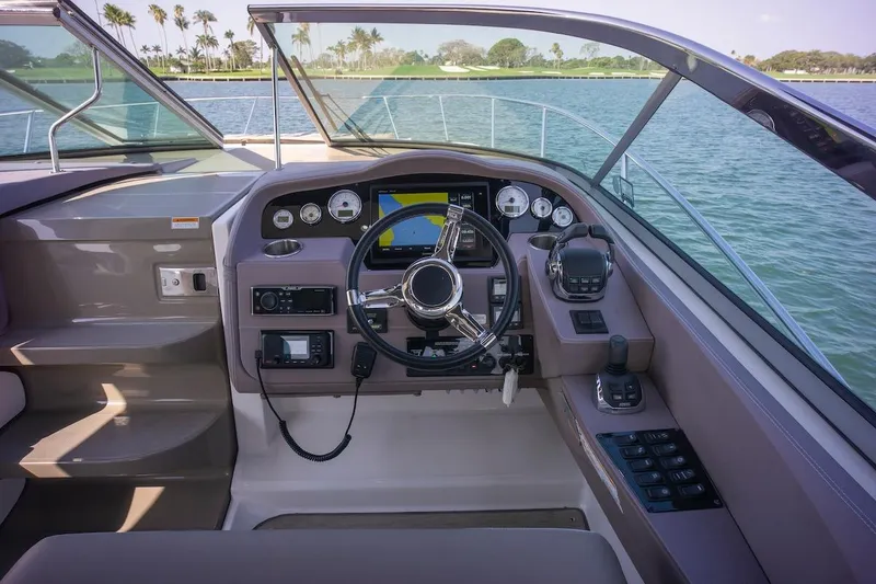 Slide: The Image of Cockpit of 2016 Regal 32 Express boat with steering wheel and control panel. - 21