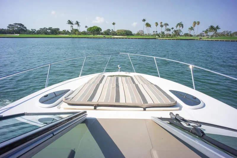 Slide: The Image of Bow view of 2016 Regal 32 Express yacht on calm water with palm trees in background. - 22