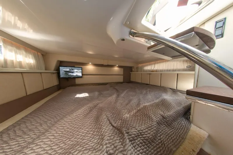Slide: The Image of Luxurious interior of 2016 Regal 32 Express yacht with cozy bedding and mounted TV. - 31