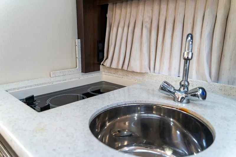 Slide: The Image of 2016 Regal 32 Express yacht kitchen with sink and stovetop. - 34
