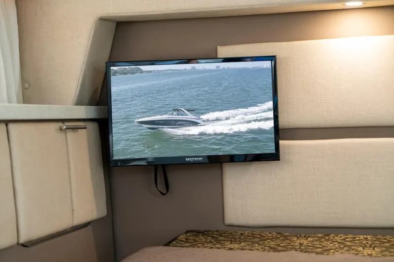 Slide: The Image of Interior of 2016 Regal 32 Express yacht with wall-mounted TV displaying a speedboat. - 37