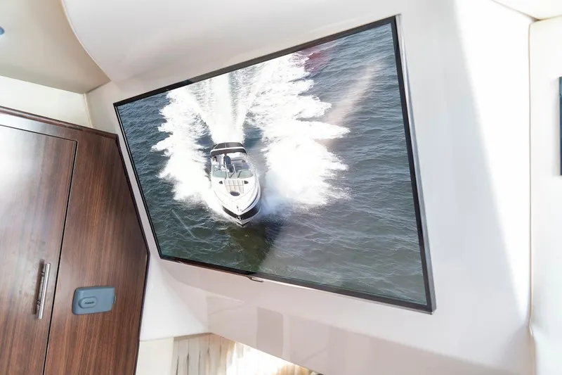Slide: The Image of Interior of 2016 Regal 32 Express yacht with wall-mounted TV displaying a boat. - 38