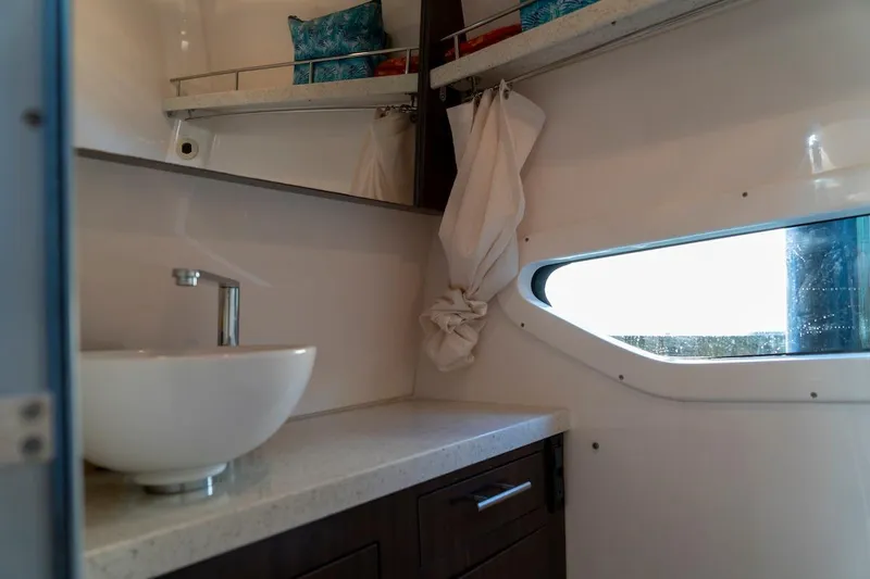 Slide: The Image of Interior of 2016 Regal 32 Express boat bathroom with sink and window. - 39