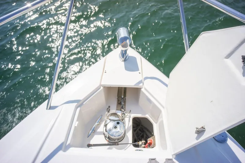 Slide: The Image of 2016 Regal 32 Express boat bow with anchor compartment open on sparkling water. - 42