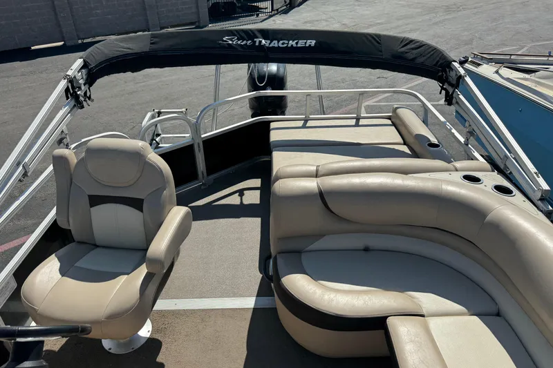 Slide: The Image of 2015 Sun Tracker Party Barge 220 DLX interior with beige seating and black canopy. - 6