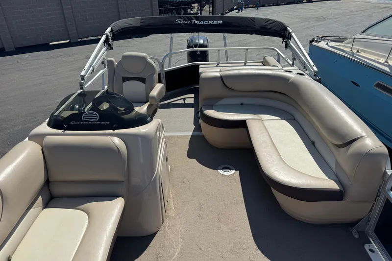 Slide: The Image of 2015 Sun Tracker Party Barge 220 DLX with spacious seating and helm, docked outdoors. - 7