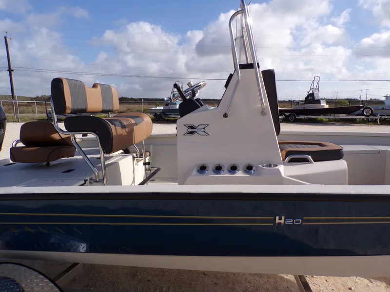 Slide: The Image of 2026 Xpress H20BAY boat with brown seats and steering console. - 26