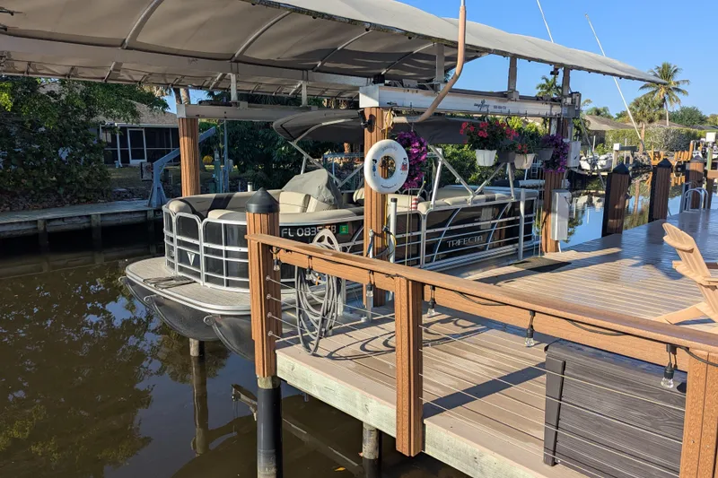 Slide: The Image of 2021 Trifecta 20CLE 2.75 pontoon boat docked with canopy and floral decorations. - 2