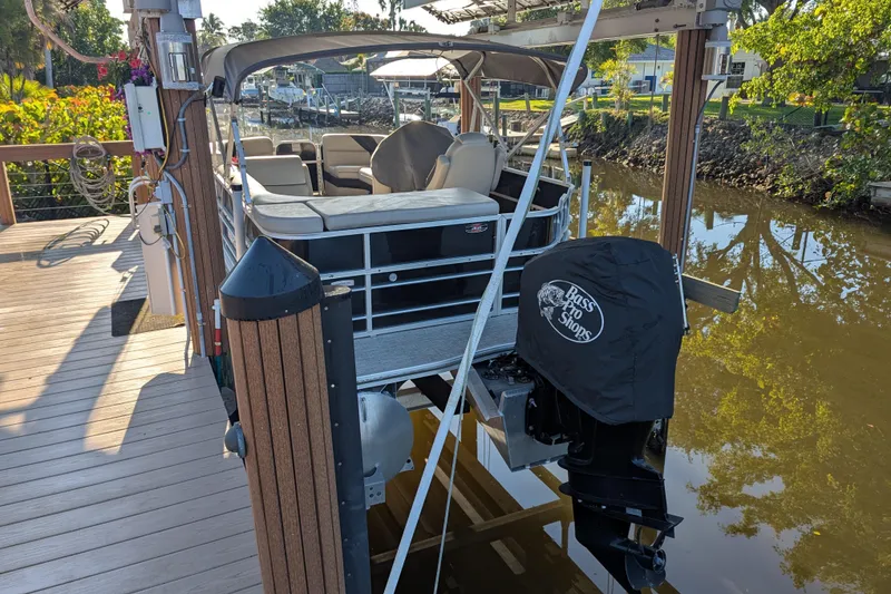 Slide: The Image of 2021 Trifecta 20CLE 2.75 pontoon boat docked on a sunny day. - 3