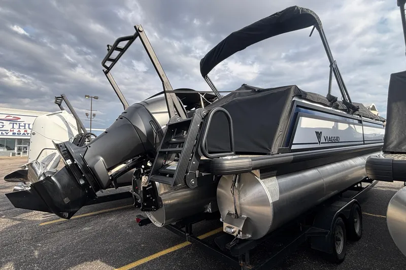Slide: The Image of 2026 Viaggio Lago X24U pontoon boat with outboard motor, parked on a trailer. - 3